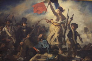 French painting of lady liberty raising the French flag and guiding revolutionaries.